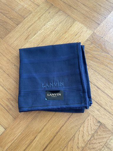 Dunkelblaues Tuch mit goldfarbenem Etikett.