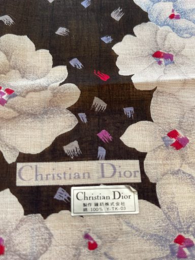 Stoffmuster mit roten und blauen Blüten, beschriftet mit "Christian Dior".